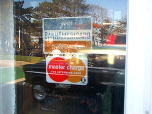 an old car happens by as i snap a shot of this window by the plymouth waterfront